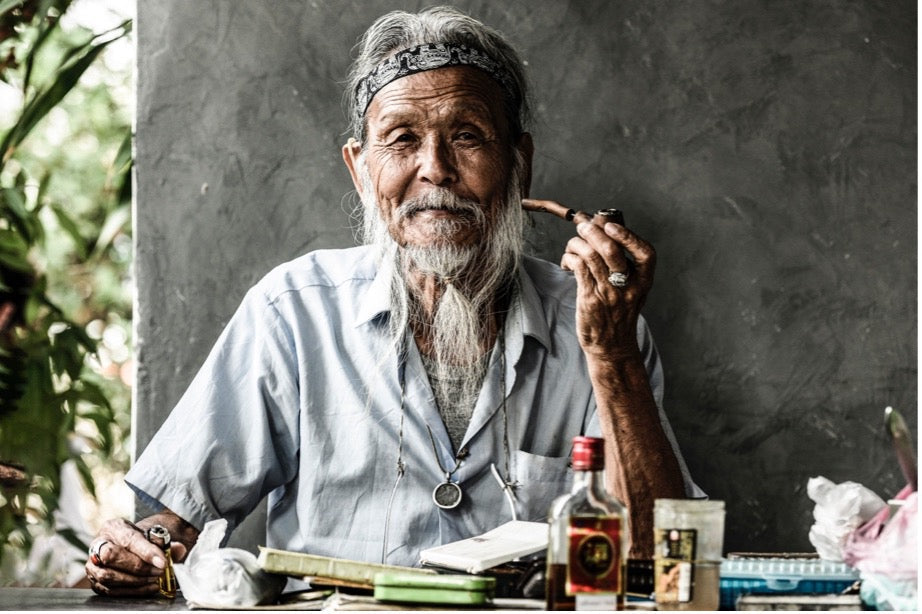 Older Asian man wearing traditional jewelry