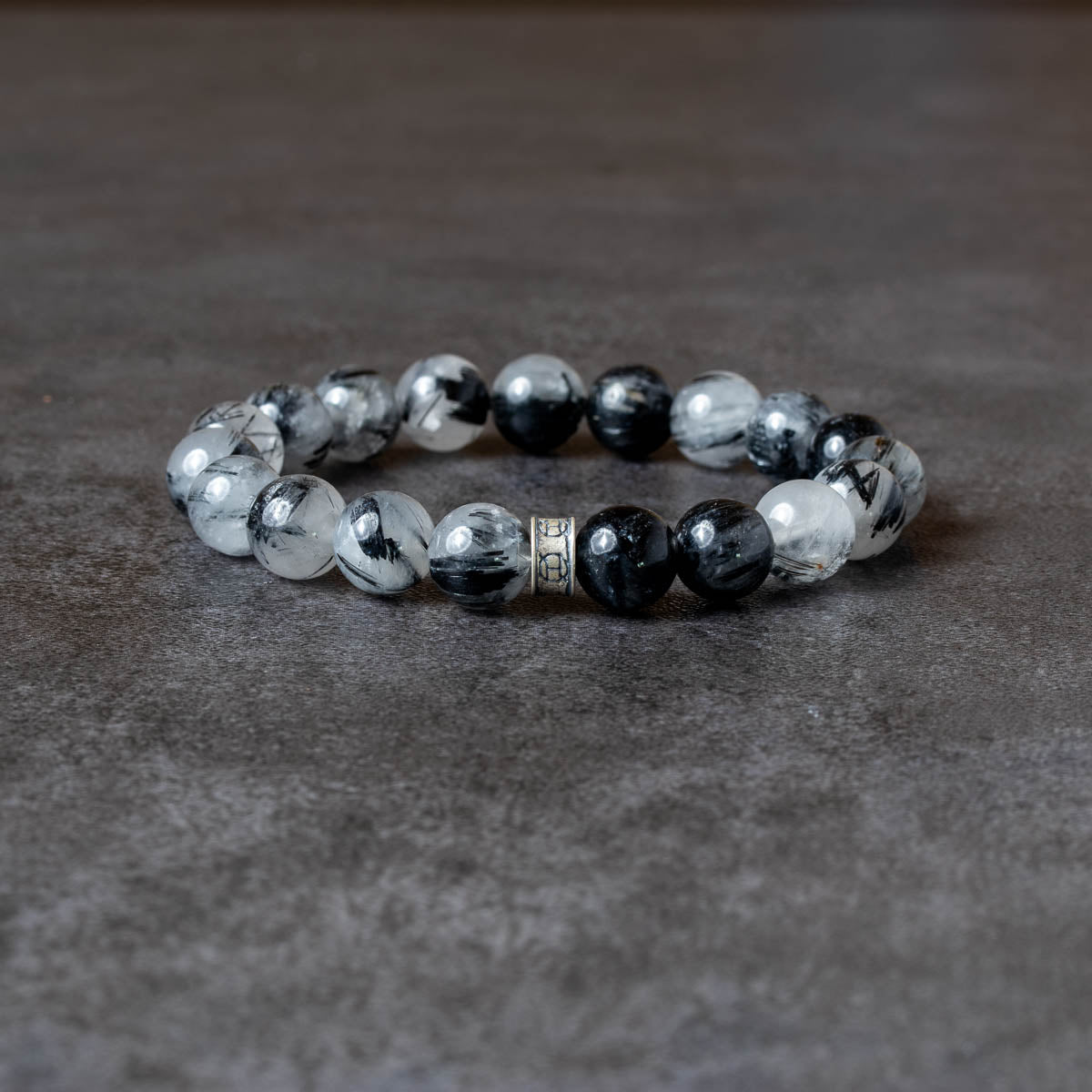 Beaded bracelet with black and white stones on a dark surface