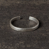 Silver bracelet on a dark textured surface