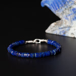 Blue lapis beaded bracelet in front of blue and white sculpture
