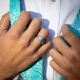 Man tying a turquoise bow tie wearing silver ring with turquoise inlay