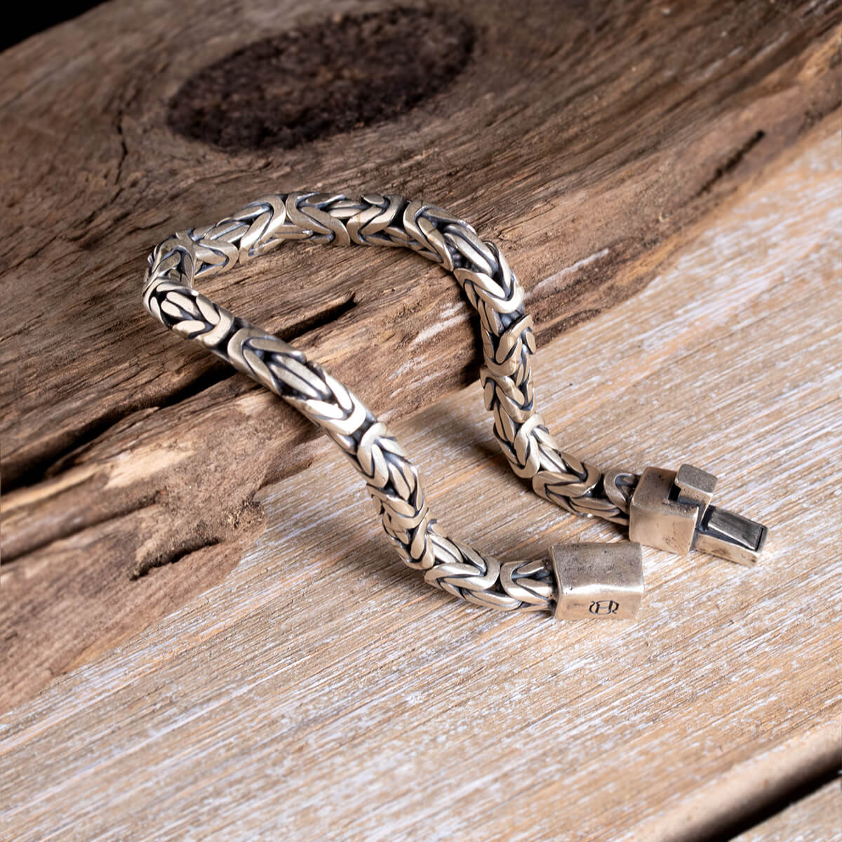 Silver braided bracelet on a wooden surface