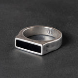 Silver ring with a black onyx  inlay on a dark background