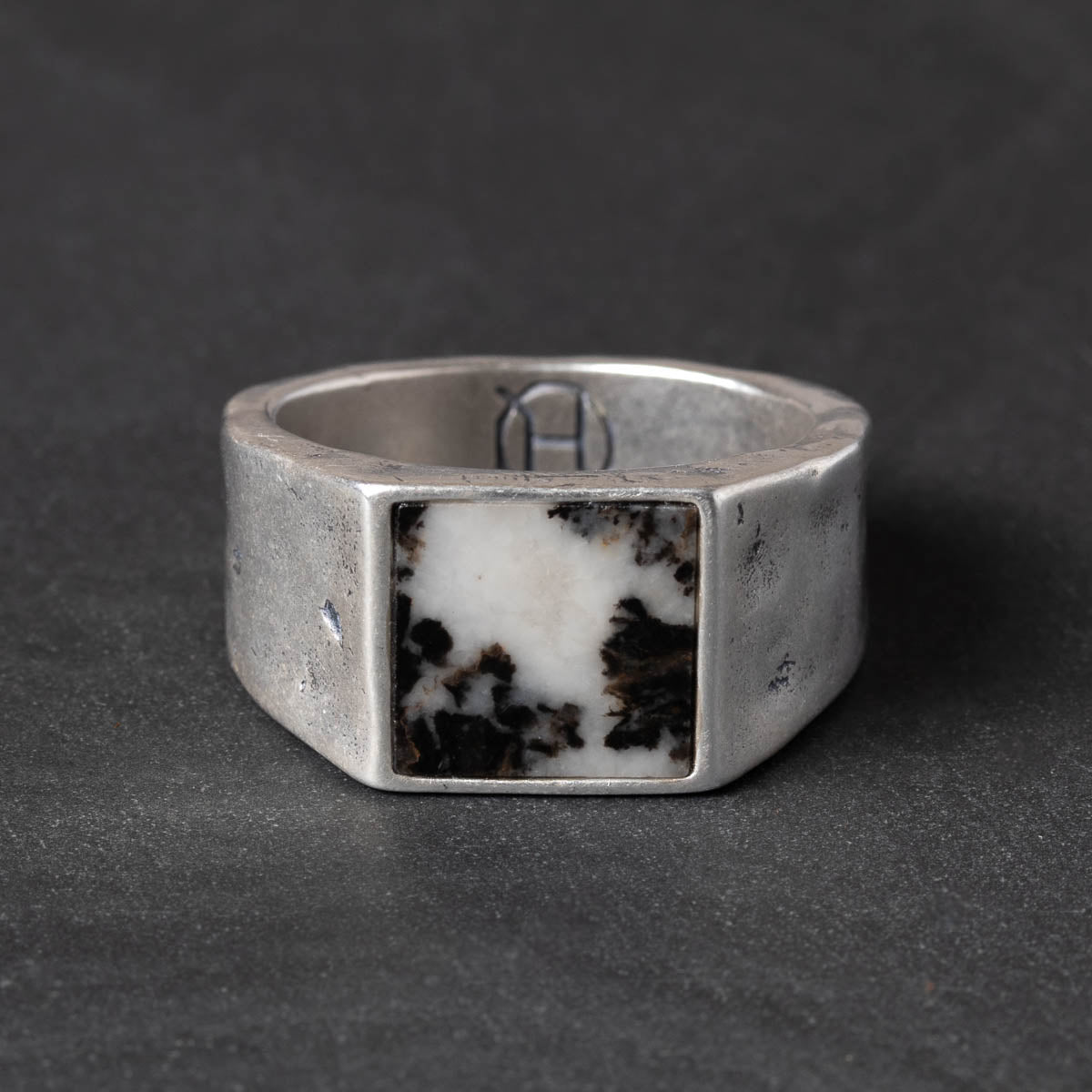 Silver ring with a square black & white zebra jasper stone on a dark gray background