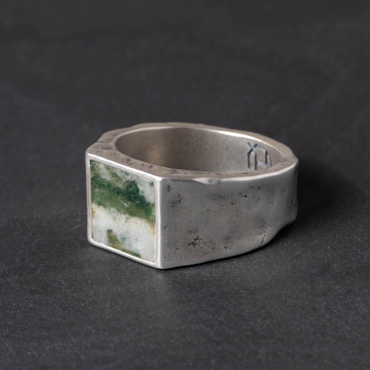 Rugged  Silver ring with a green moss agate inlay stone on a dark background