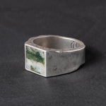 Rugged  Silver ring with a green moss agate inlay stone on a dark background