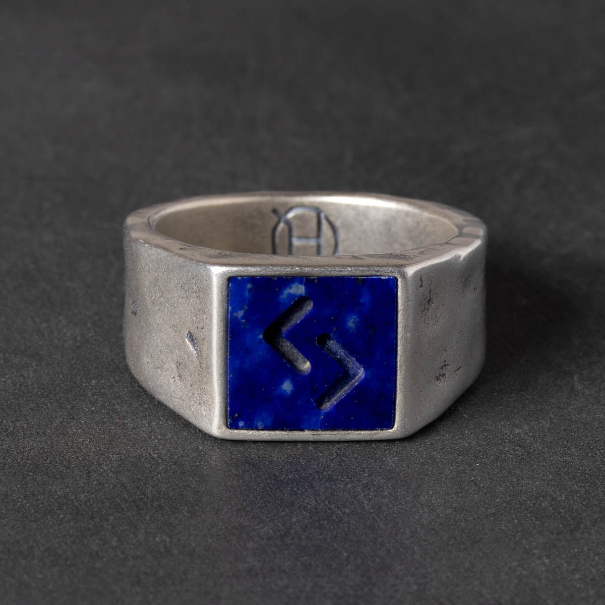 Silver ring with a blue square lapis lazuli inlay on a dark gray background