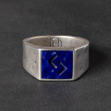 Silver ring with a blue square lapis lazuli inlay on a dark gray background