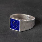 Silver signet ring with blue lapis inlay on a dark gray background