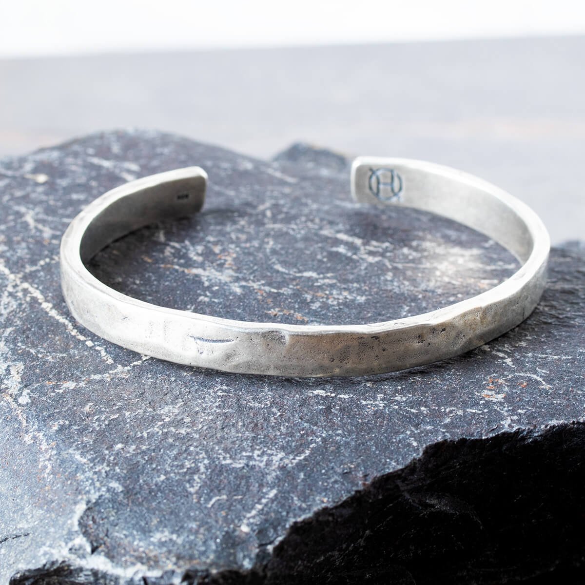 Silver cuff on a textured stone surface