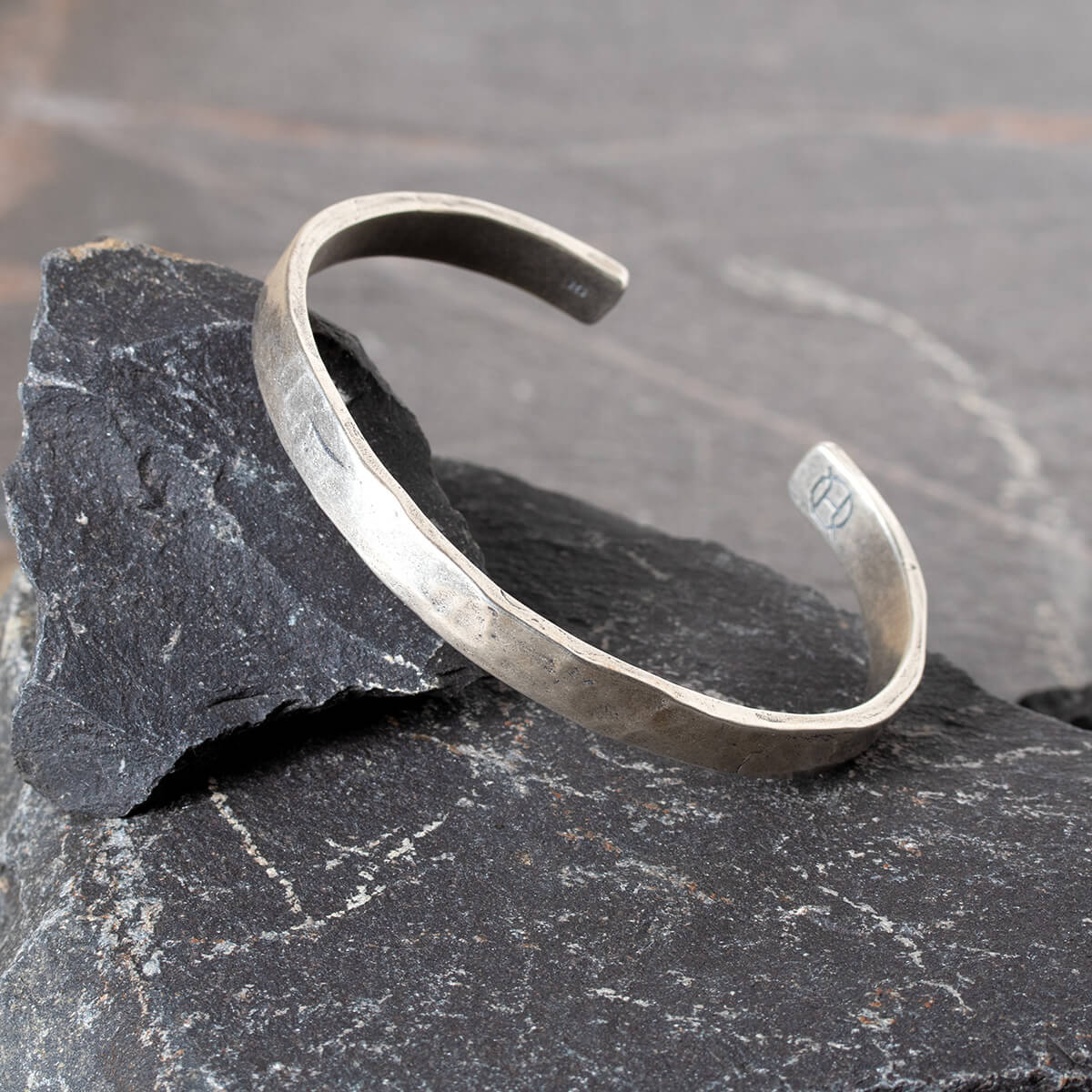Silver cuff on a dark stone surface
