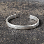 Silver cuff on a textured dark surface