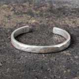 Silver cuff on a textured dark surface