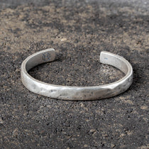 Silver cuff on a textured dark surface
