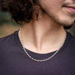 Model in black shirt wearing silver mariner chain