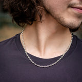 Model in black shirt wearing silver mariner chain