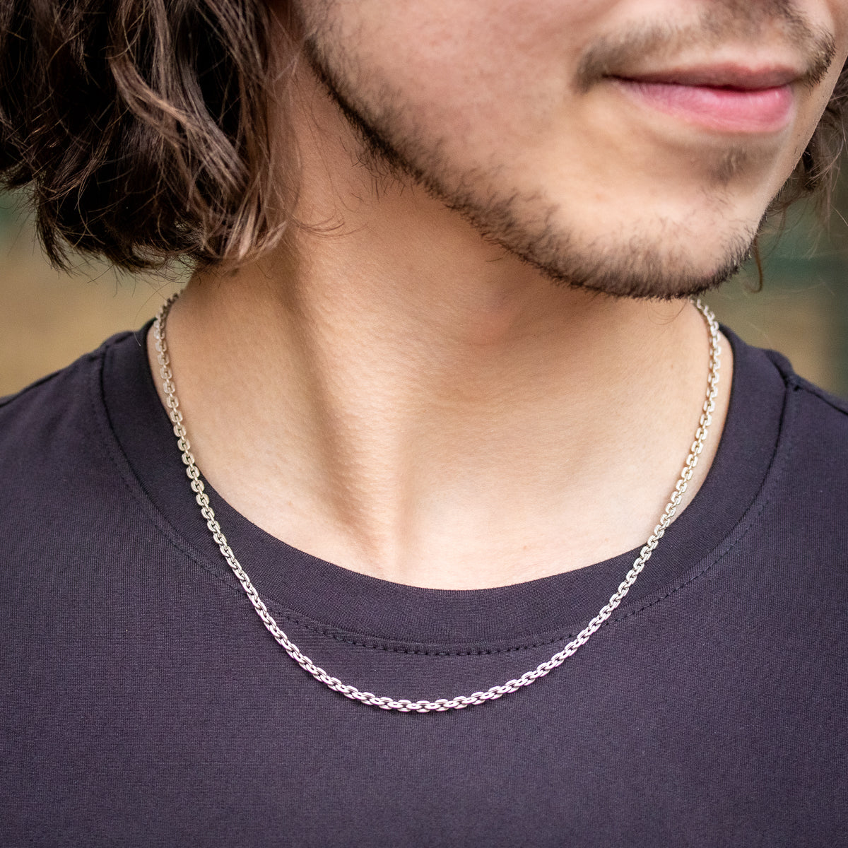 Man in black t-shirt wearing silver box chain