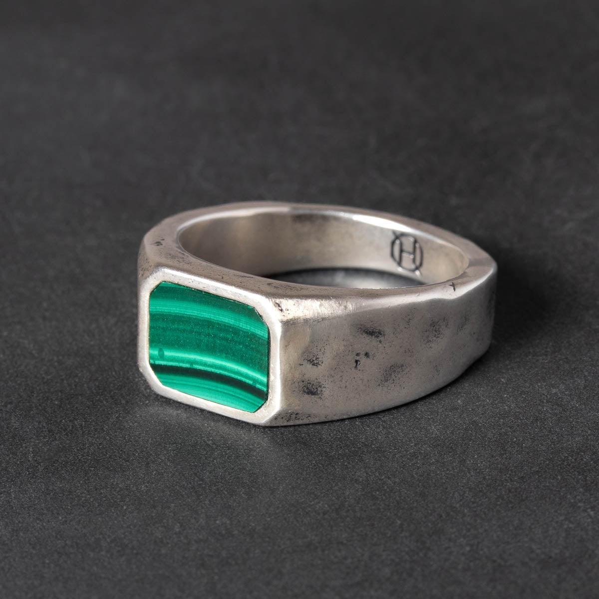 Silver ring with a Malachite inlay on a dark background