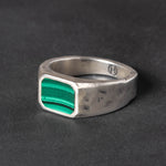 Silver ring with a Malachite inlay on a dark background
