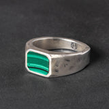 Silver ring with a Malachite inlay on a dark background