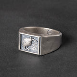 Silver ring with a kiwi bird emblem on a dark background