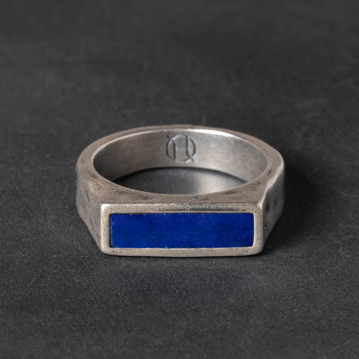 Narrow Silver signet ring with a blue lapis stone on a dark background