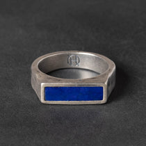 Narrow Silver signet ring with a blue lapis stone on a dark background