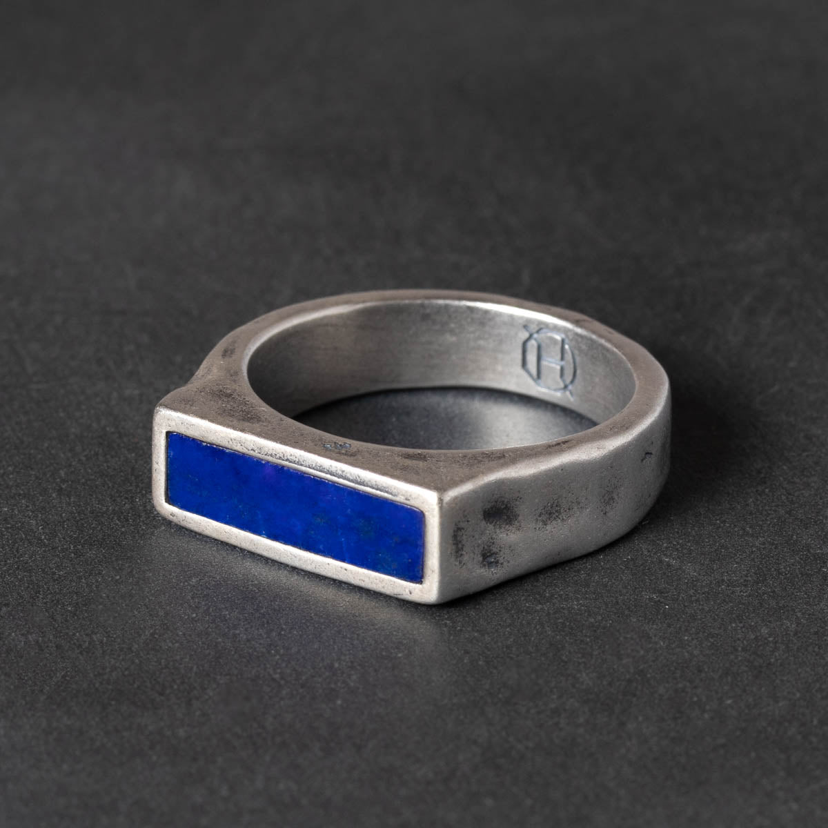 Narrow Silver signet ring with a blue lapis inlay on a dark background