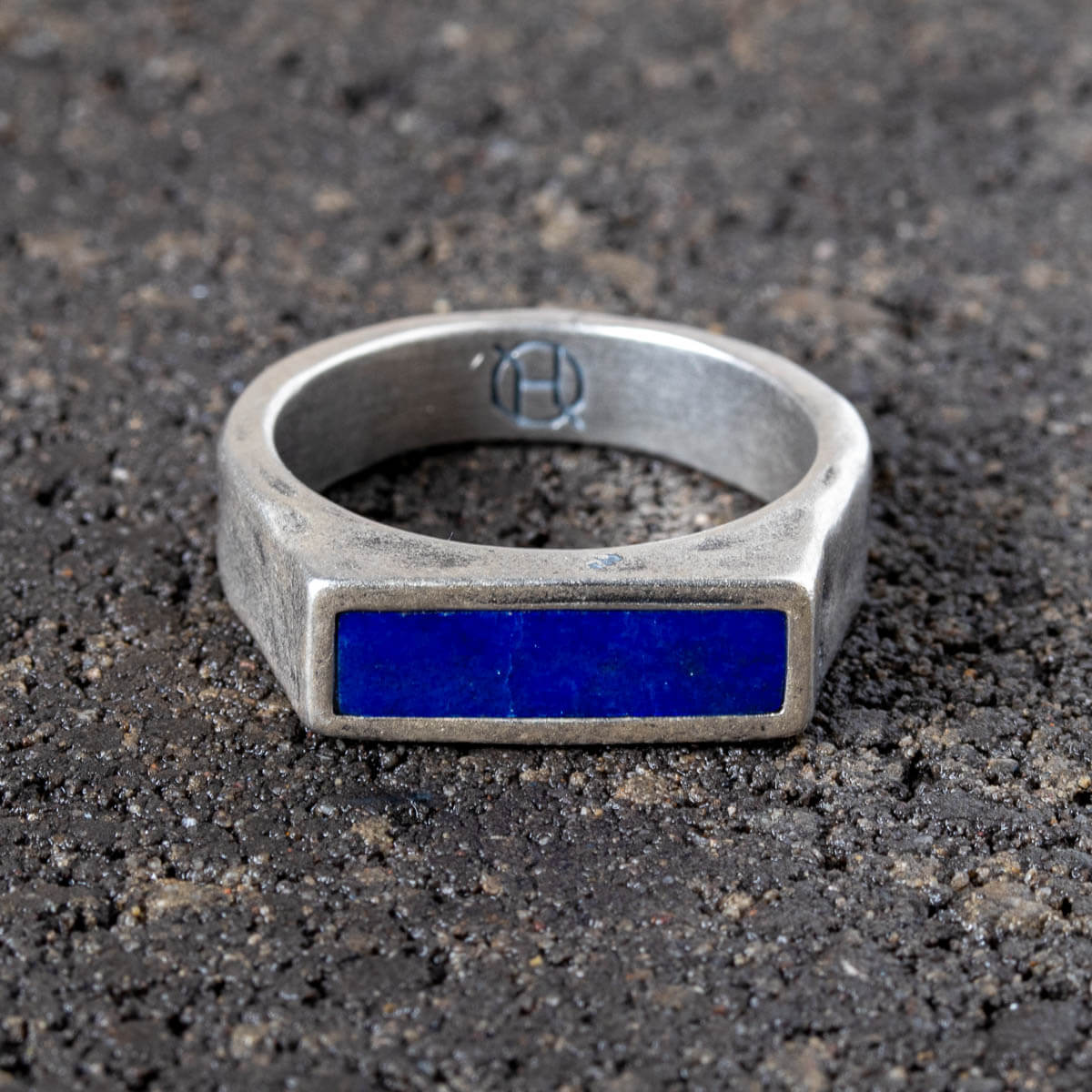 Silver ring with a blue lapis lazuli stone on a dark textured surface