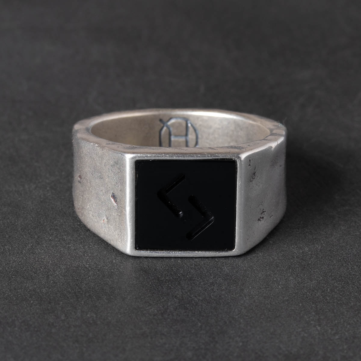 Silver signet ring with a carved black onyx stone and the jera rune