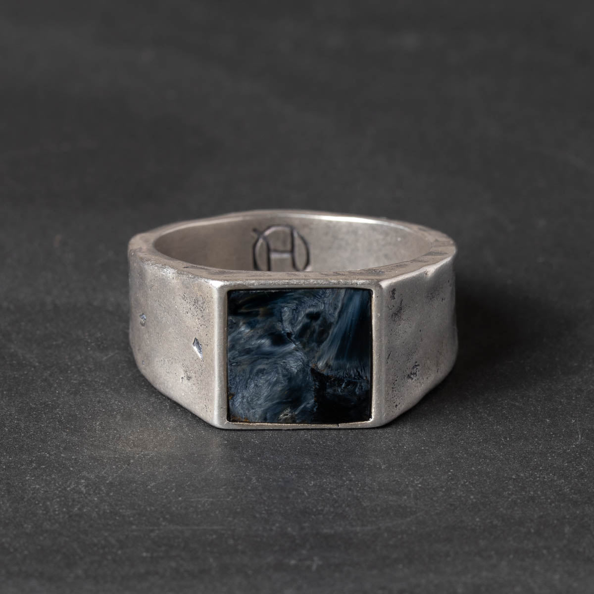 Silver ring with a square slate blue pietersite stone on a dark background