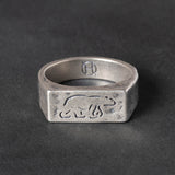 Silver ring with engraved polar bear design on a dark gray background