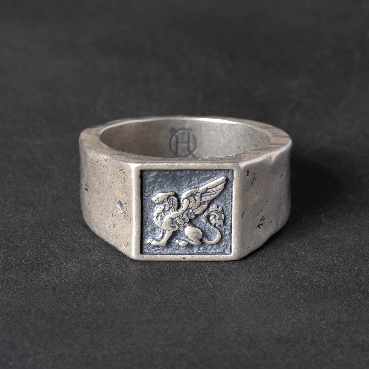Silver Signet ring with a griffin carving on a dark background