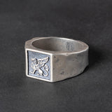 Rugged Silver signet ring with a griffin carving on a dark background