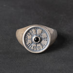 Silver signet ring with a vegvisir design and black onyx stone on a dark background