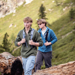 Two people hiking in a mountainous area with backpacks.