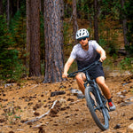 Person mountain biking on a trail in a forest